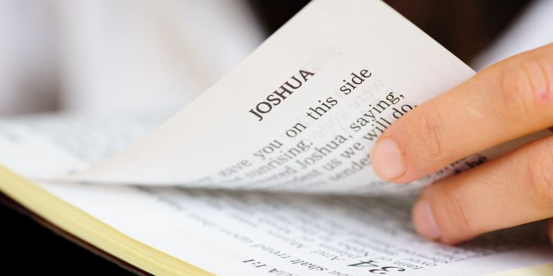A Bible open to Joshua 24-15 or 1 Corinthians 13-4-7, with a soft light highlighting the pages.