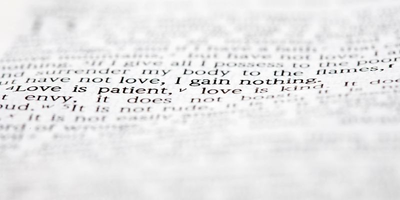 A Bible open to a relevant passage (e.g., 1 Corinthians 13-4-7)
