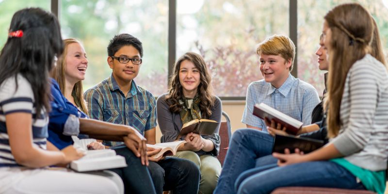 A peaceful, diverse group of students engaged in a discussion or reading the Bible together