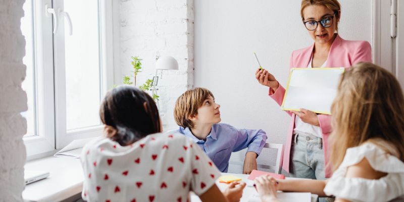 A teacher modeling respectful behavior with students in a classroom, or students engaged in conflict resolution